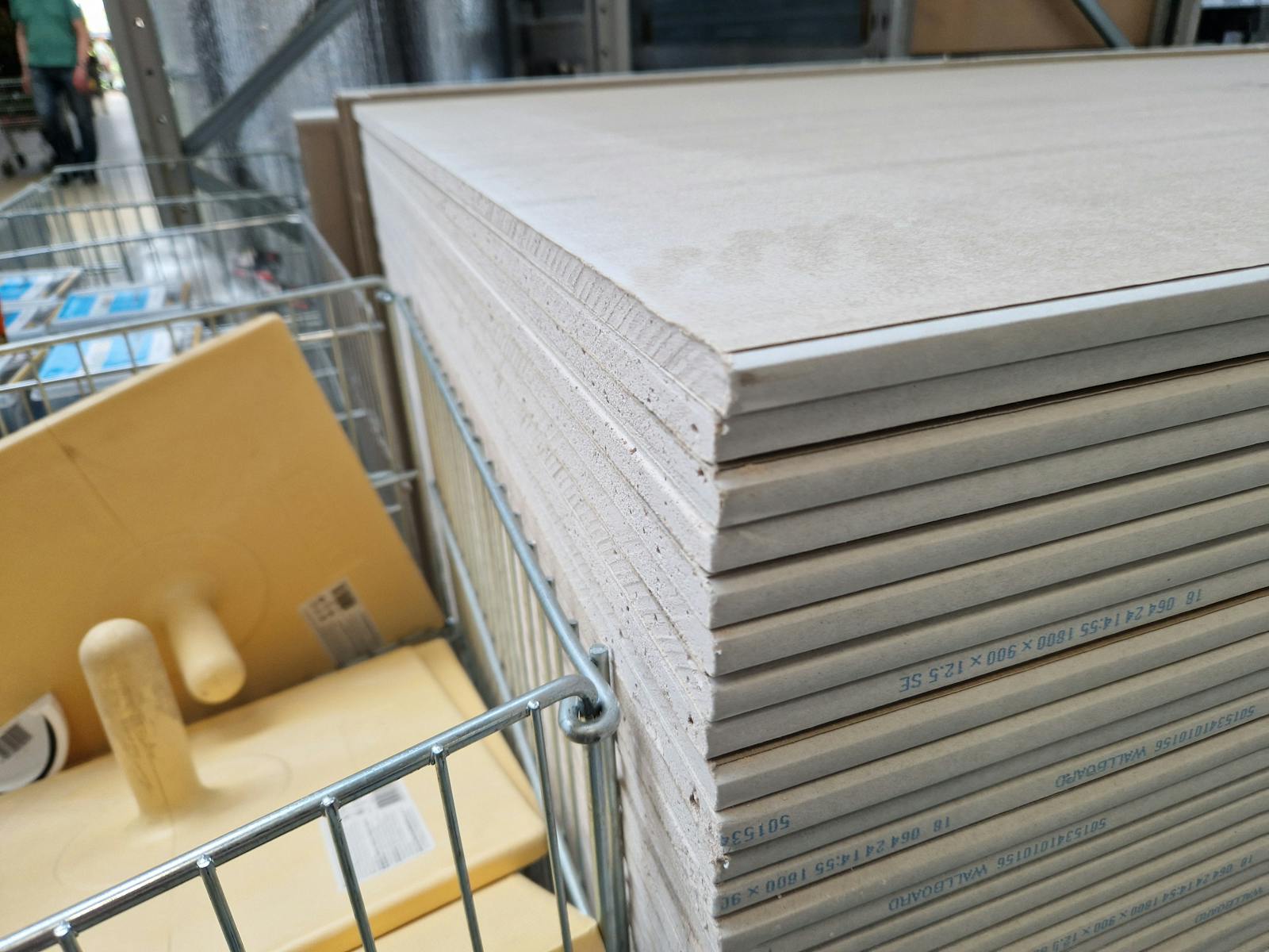 Drywall panels stacked in a London warehouse, ideal for construction projects