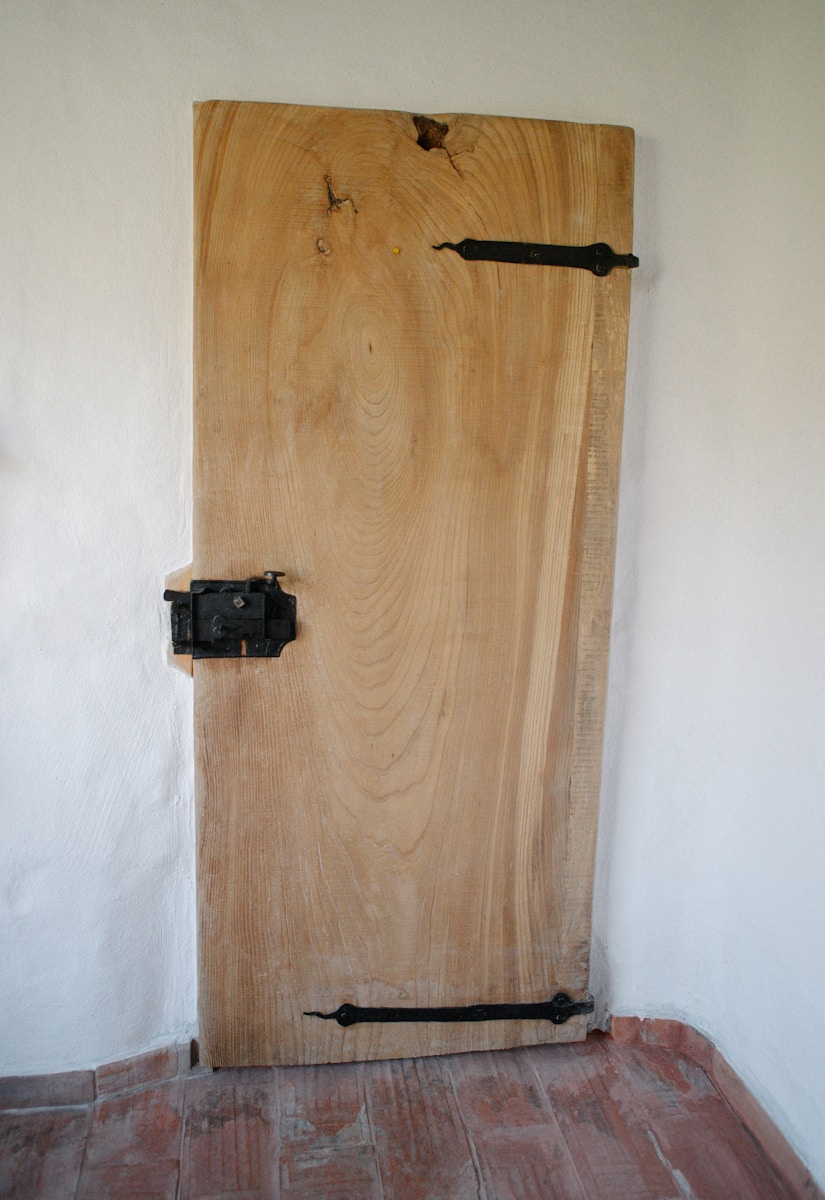 A wooden door in a room with a brick floor