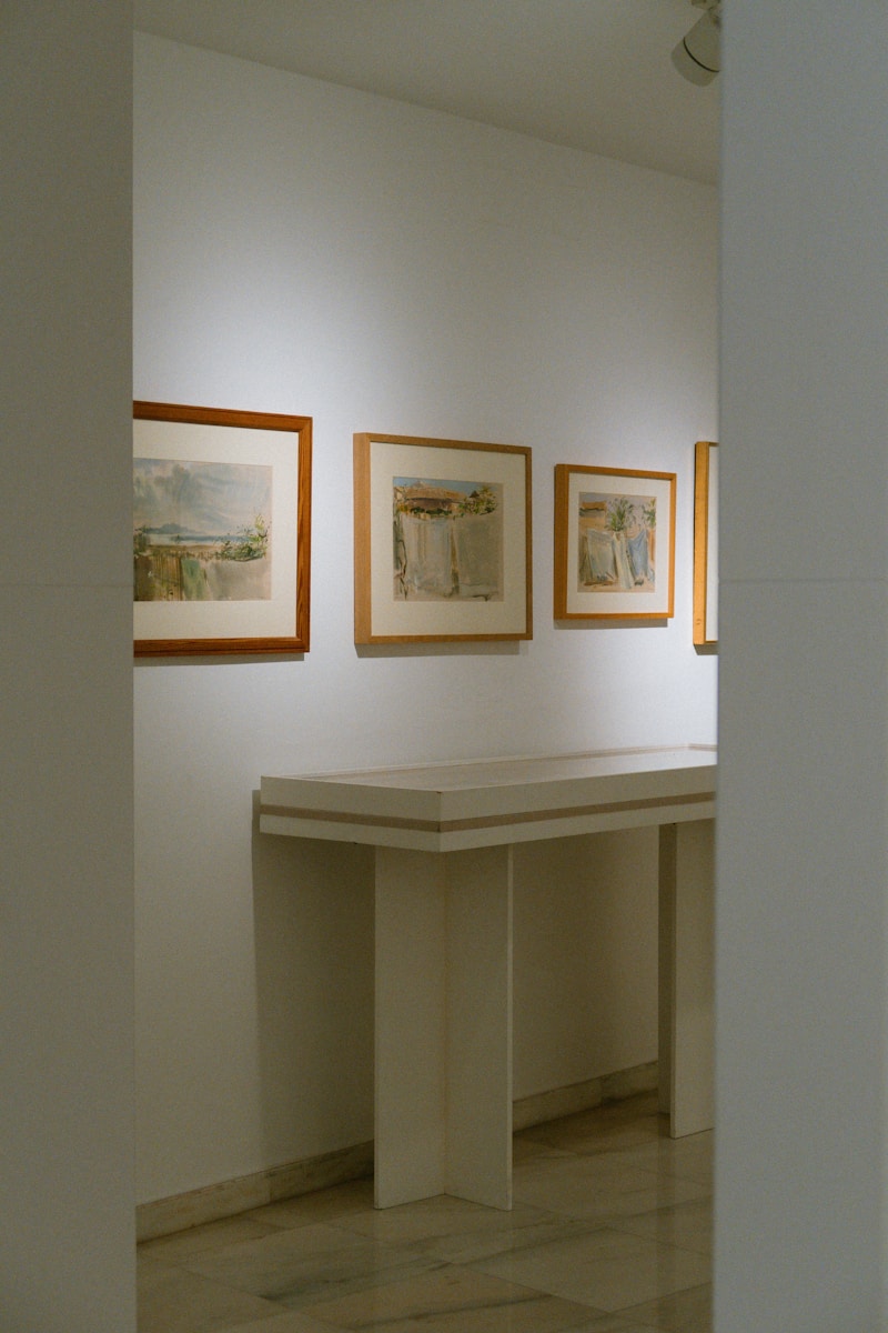 a room with a table and paintings on the wall